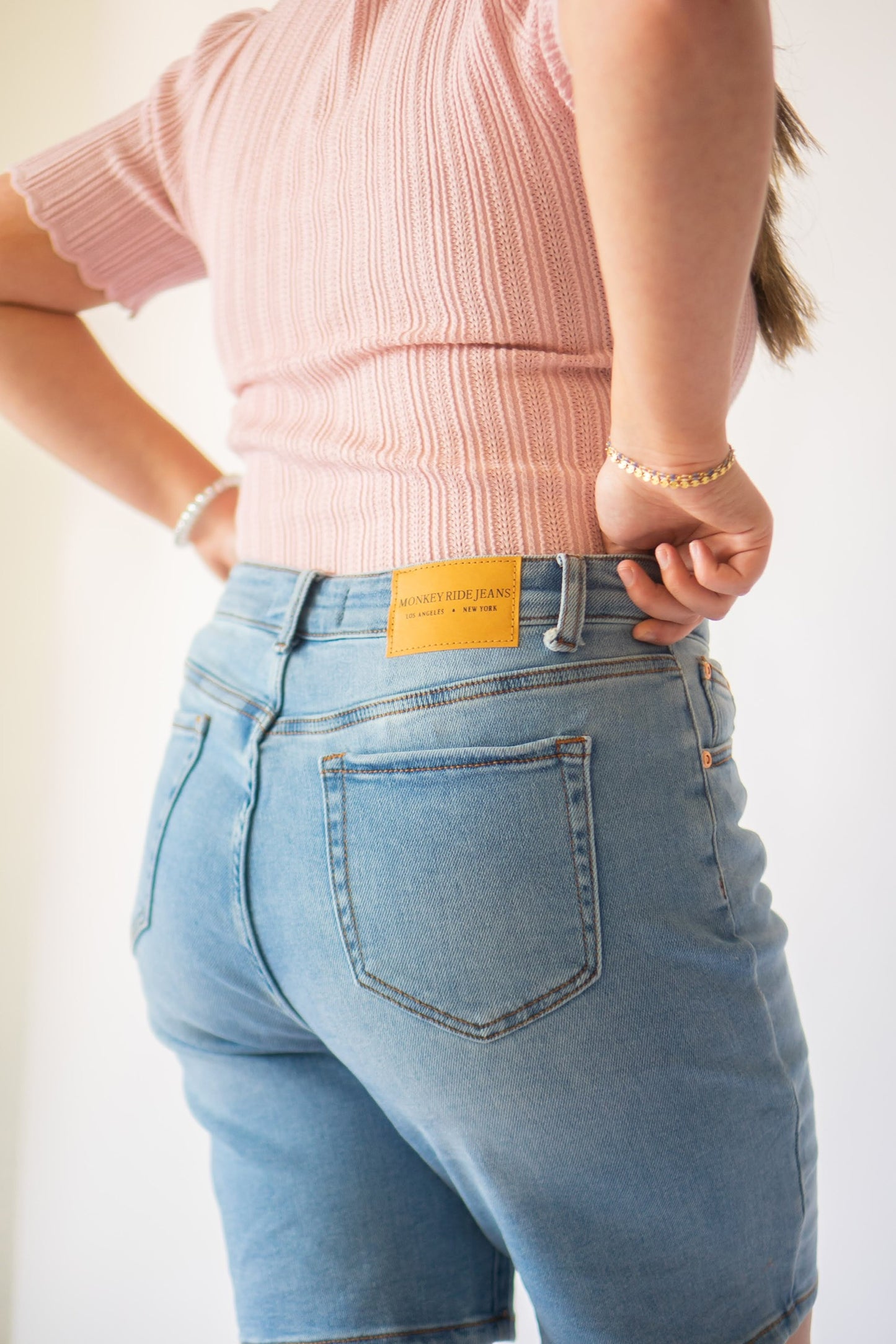 Back of non-distressed stretch denim shorts.