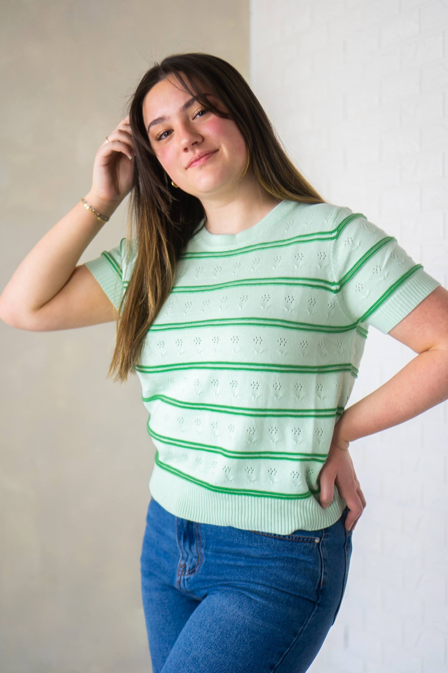 Green floral knit blouse with dark green double stripe pattern.