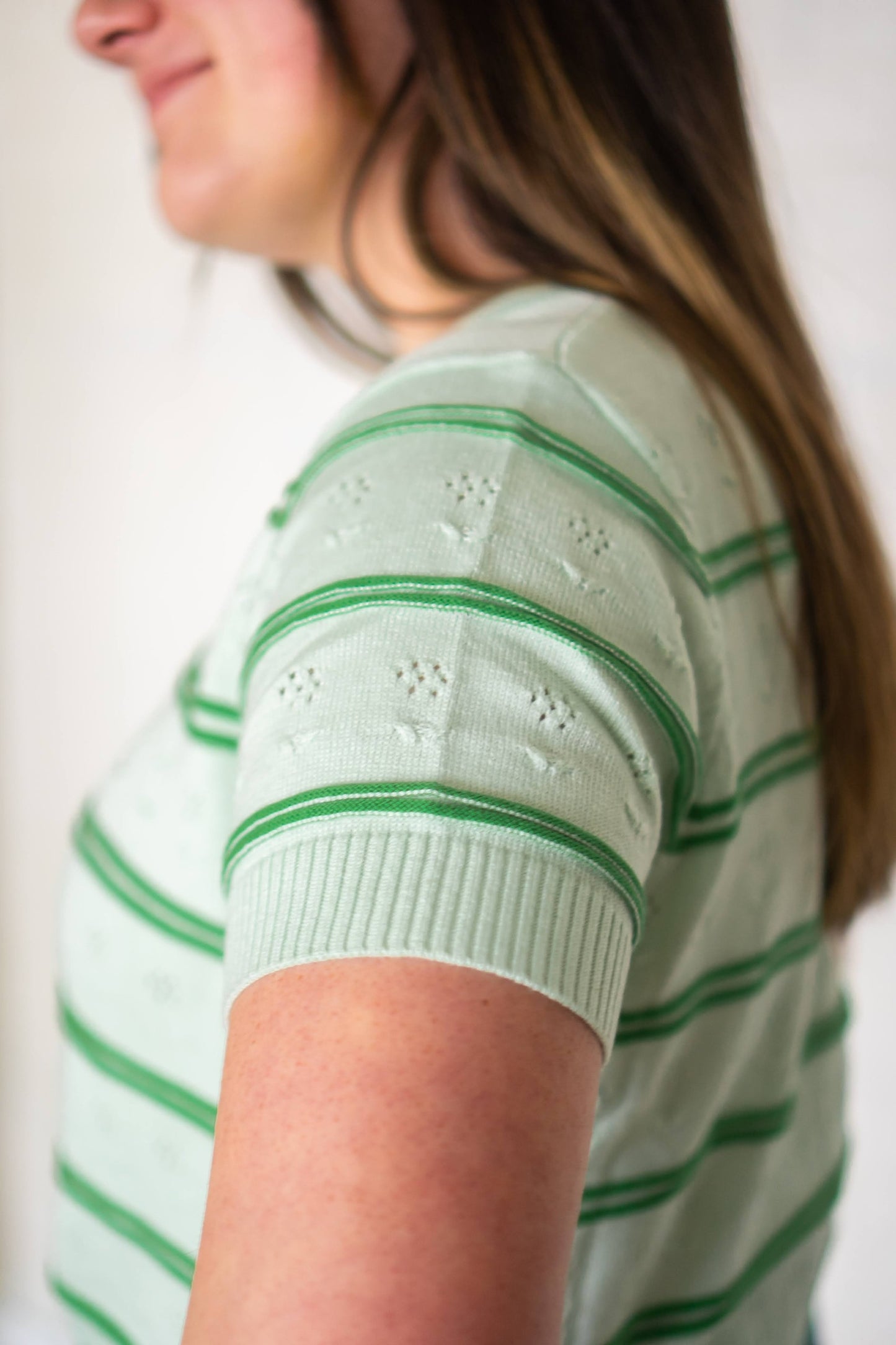 Sleeve of green floral knit blouse.