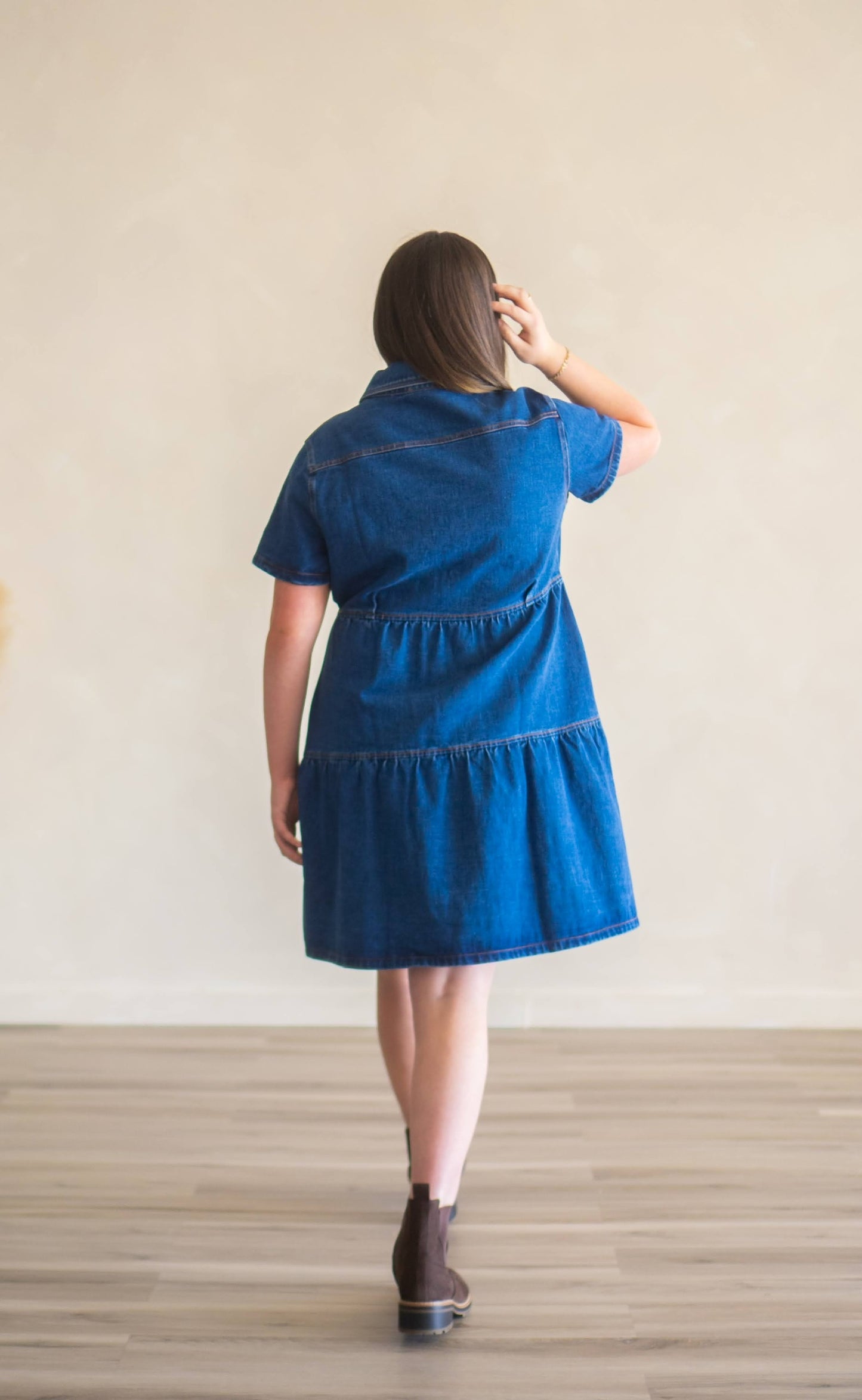 Back of Cassidy denim dress, featuring two tiers, short sleeves, and knee-length style.