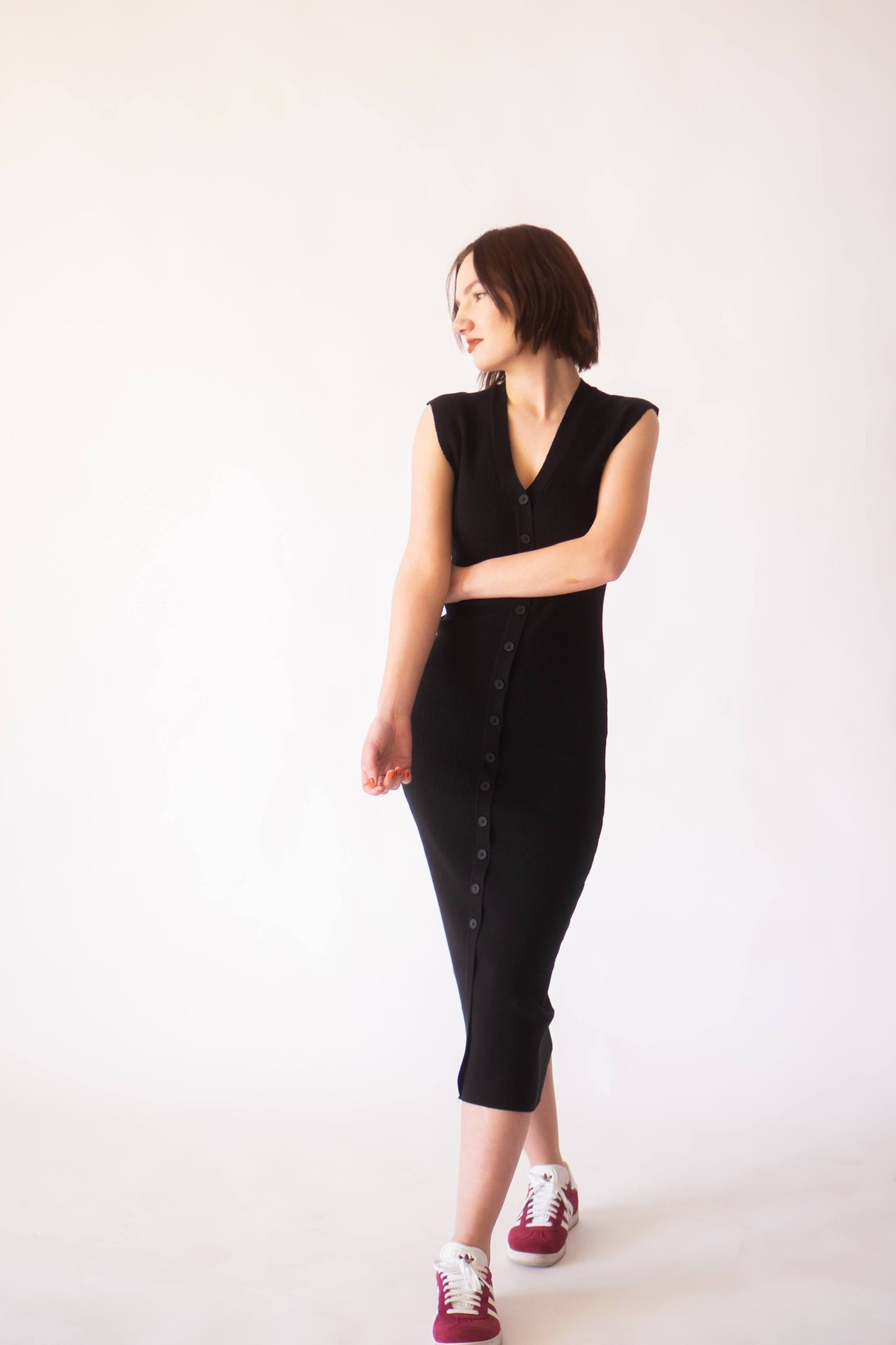 Woman wearing midi button up black knit dress.