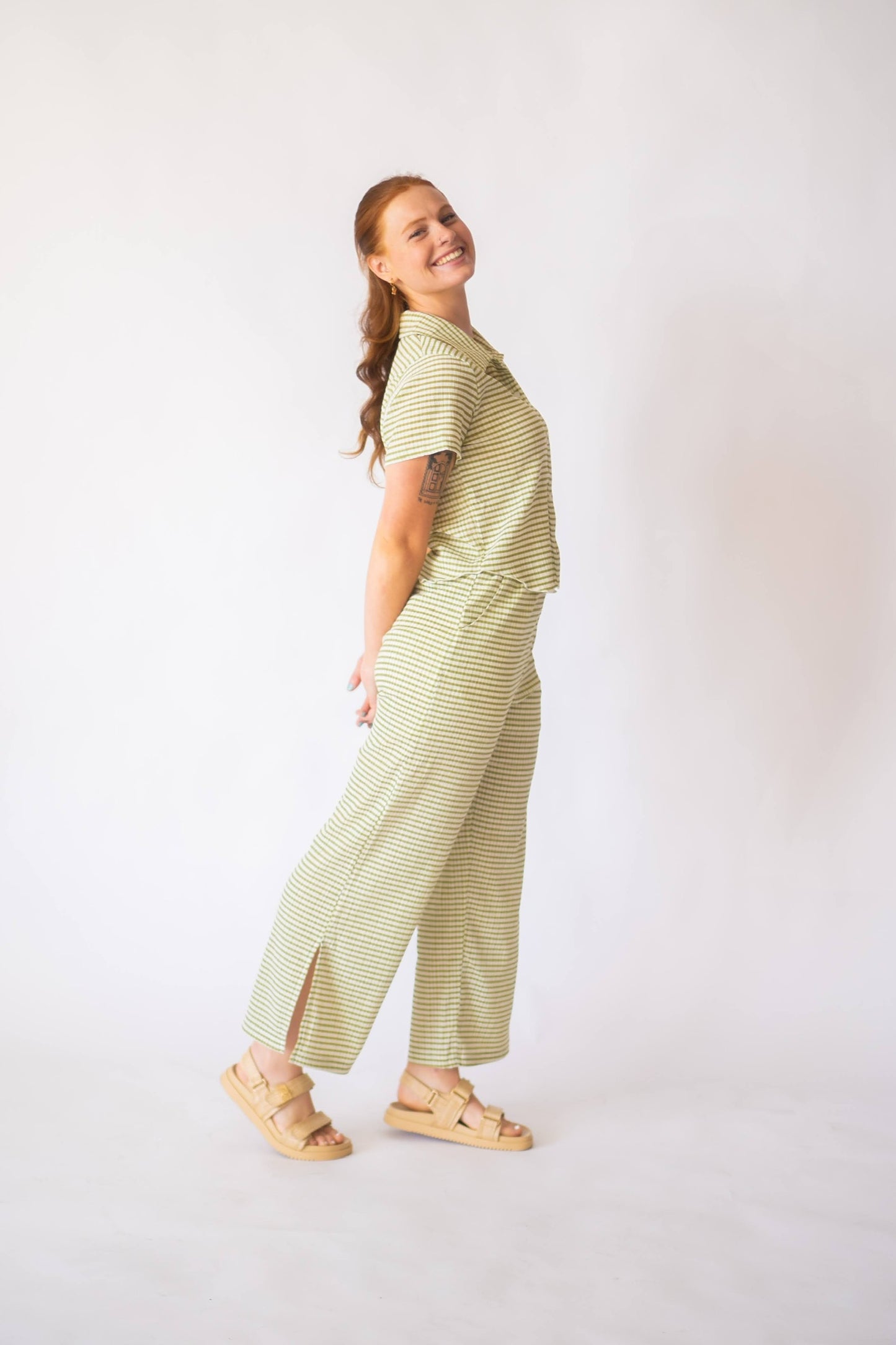 Woman wearing a green striped outfit on a white background