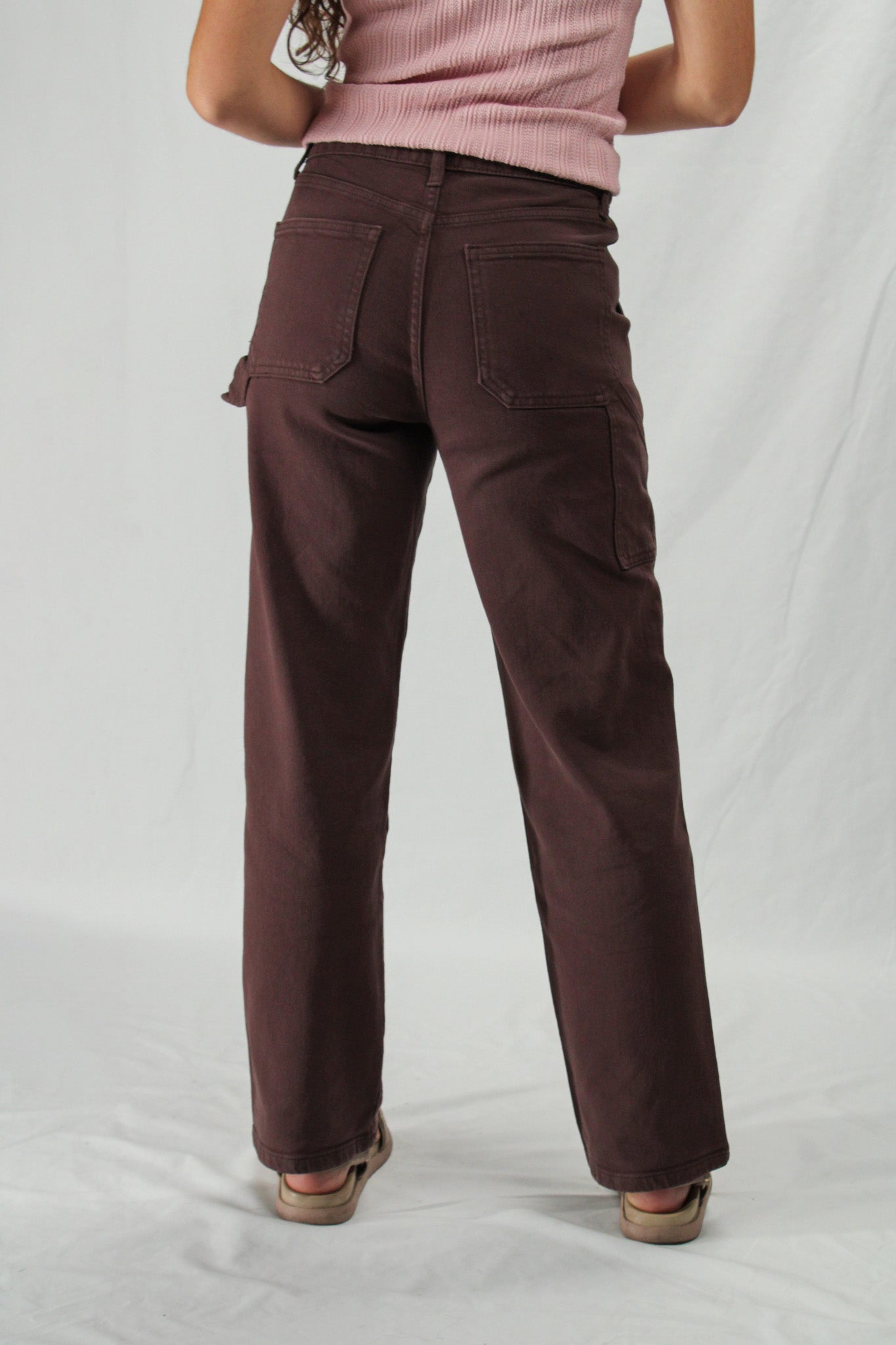 Brown cargo pants worn by a person on a white background