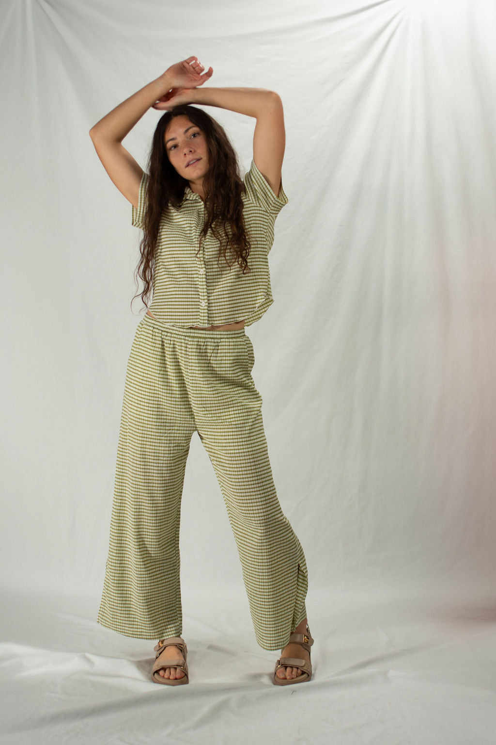 Woman wears green striped matching set with wide leg bottoms and button up top