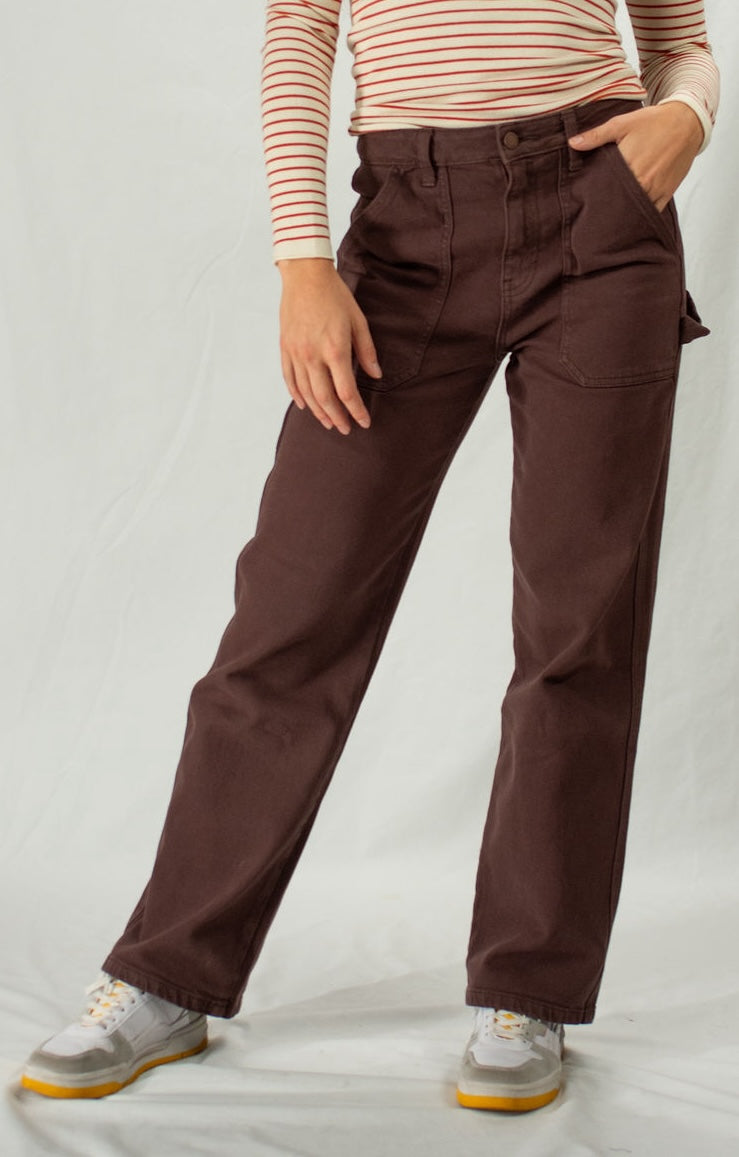 Person wearing brown cargo pants and a striped shirt on a plain background