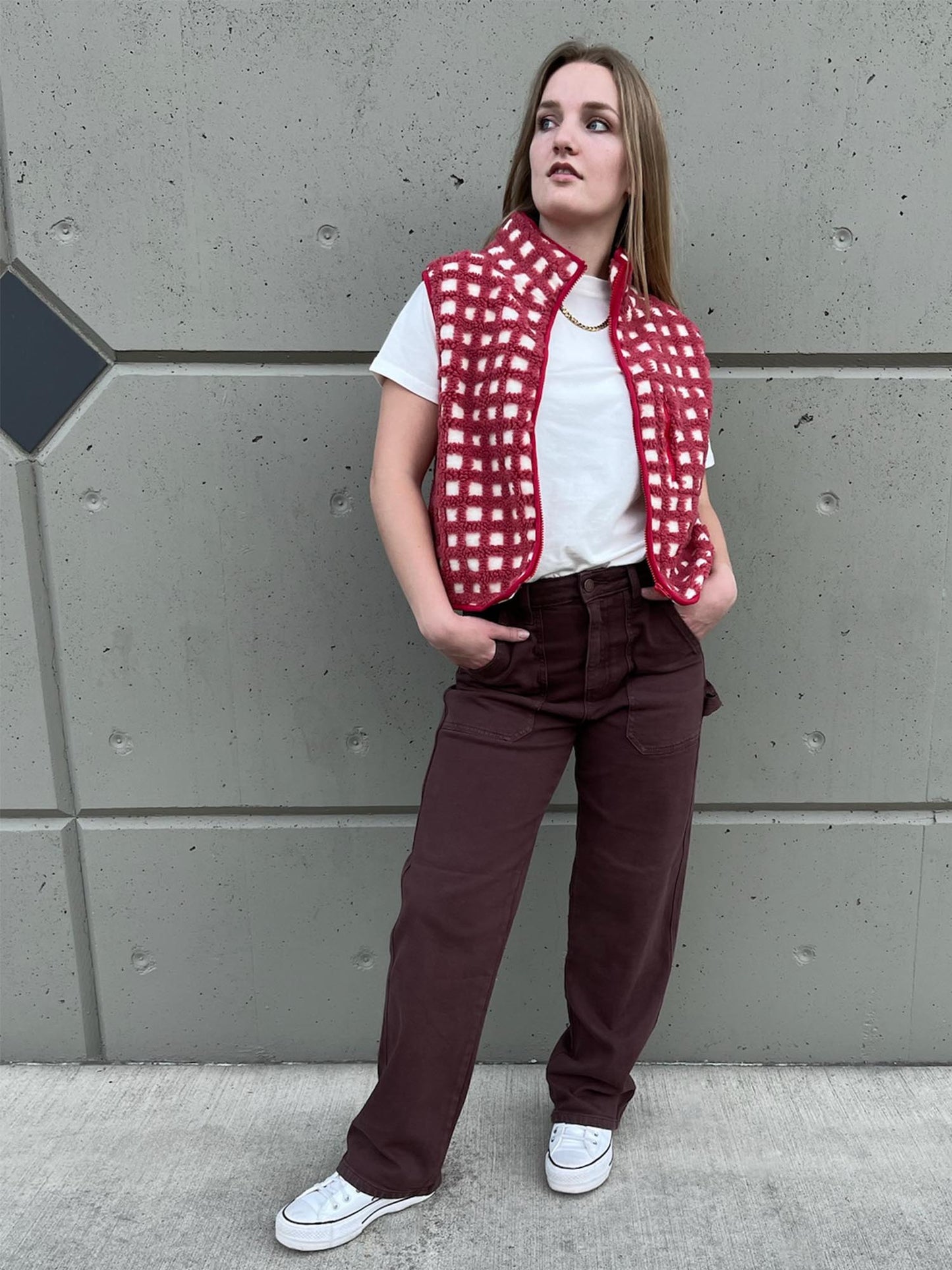 Girl wearing plaid zip up vest with white tee and brown carpenter jeans