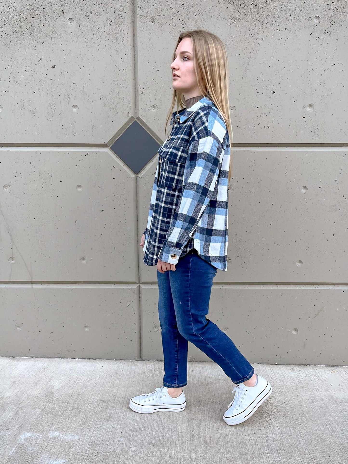 Girl walking while wearing blue plaid two tone shacket and straight leg jeans