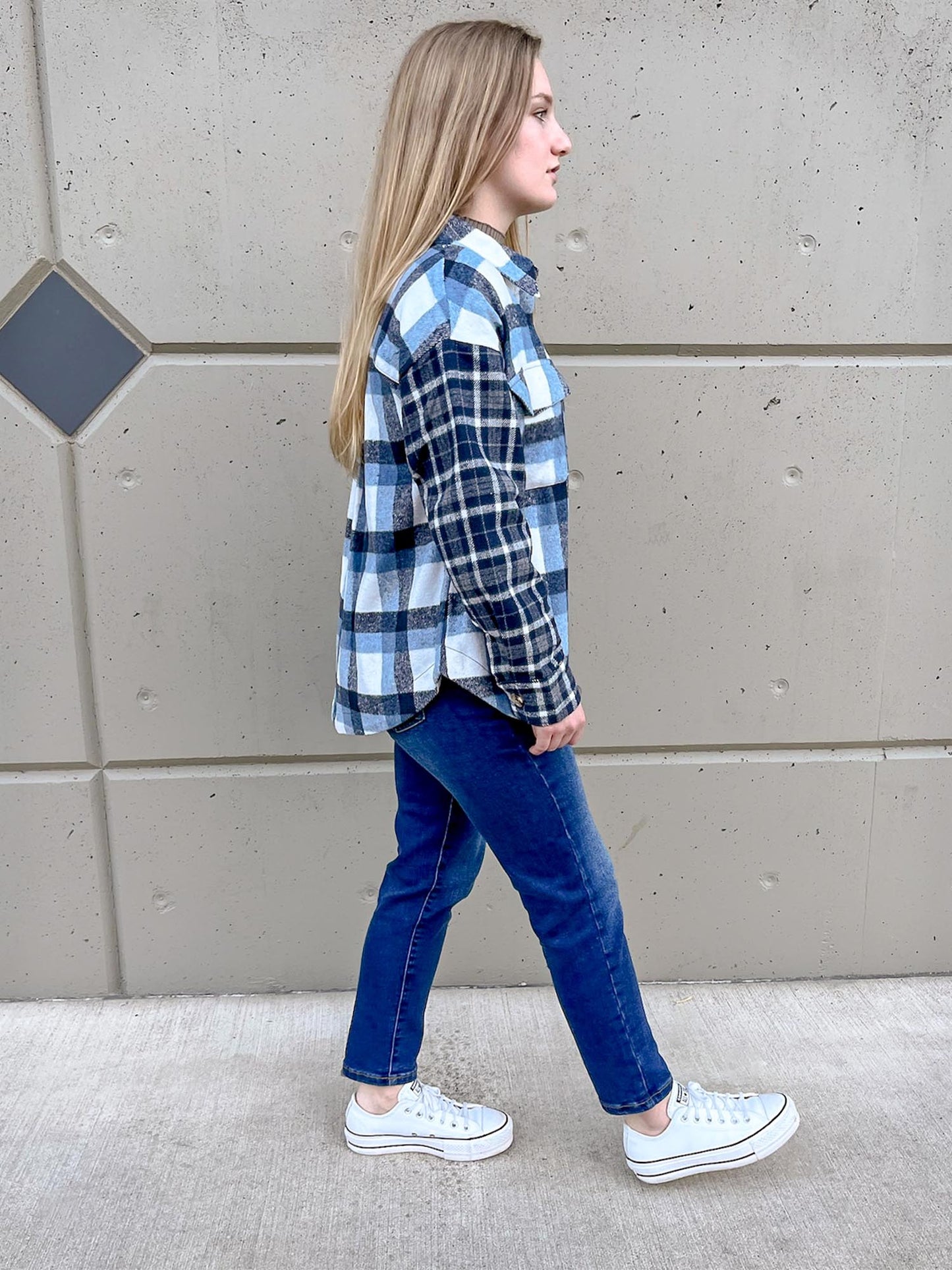 Girl walking while wearing blue plaid two tone shacket and straight leg jeans