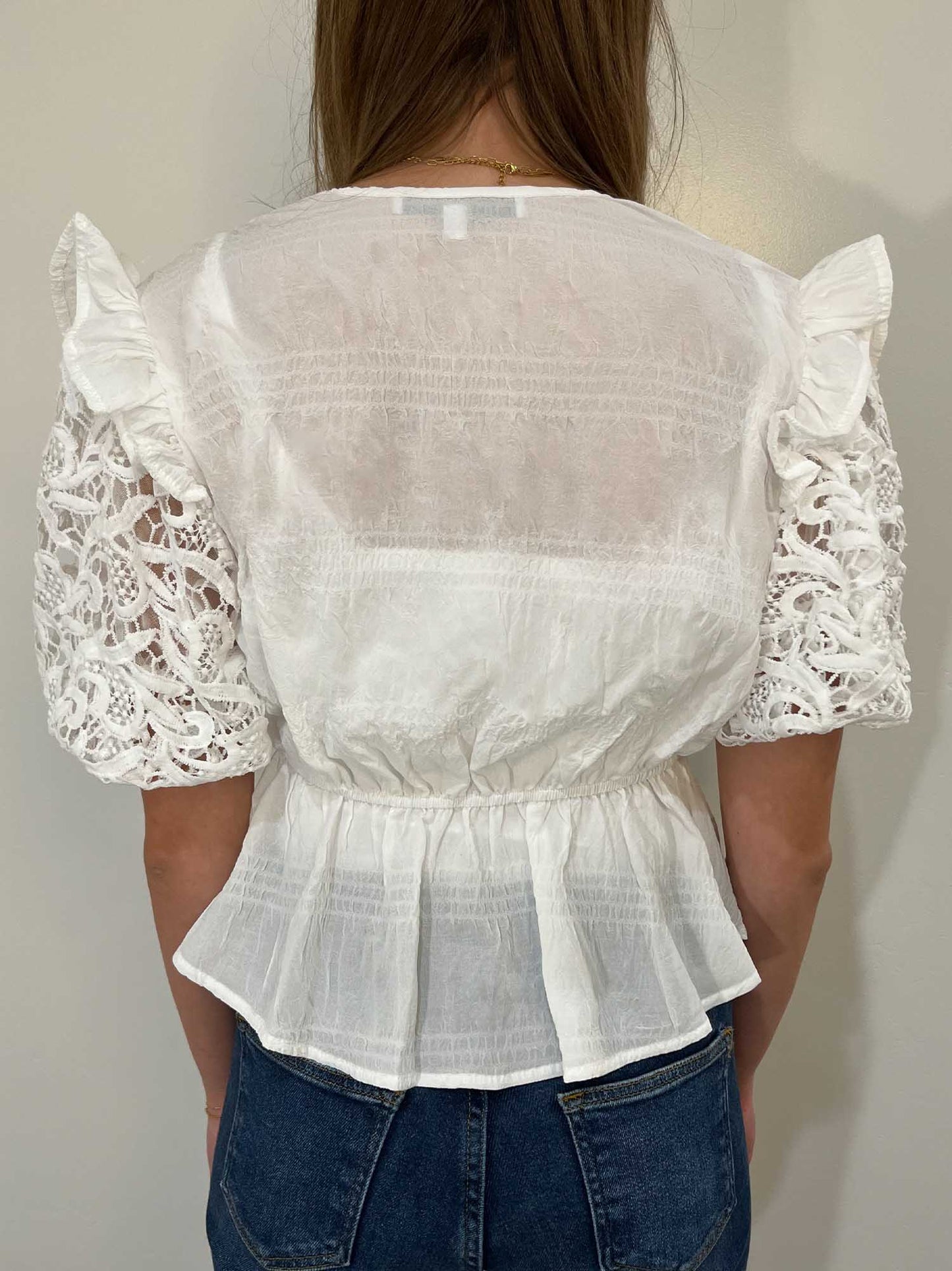 White lace, puff-sleeve peplum blouse from behind