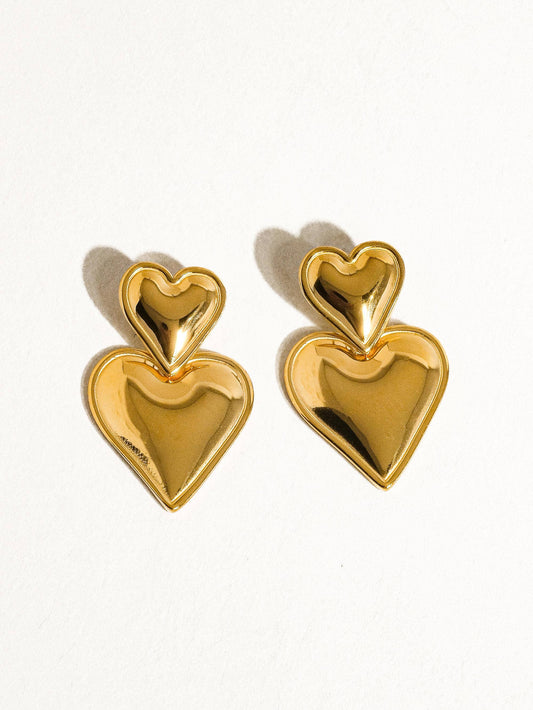 Gold heart-shaped earrings on a white background
