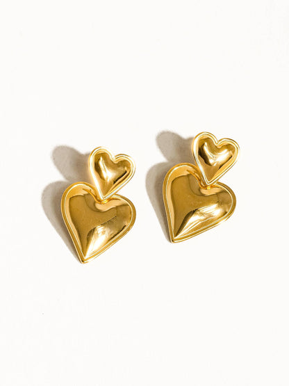 Gold heart-shaped earrings on a white background