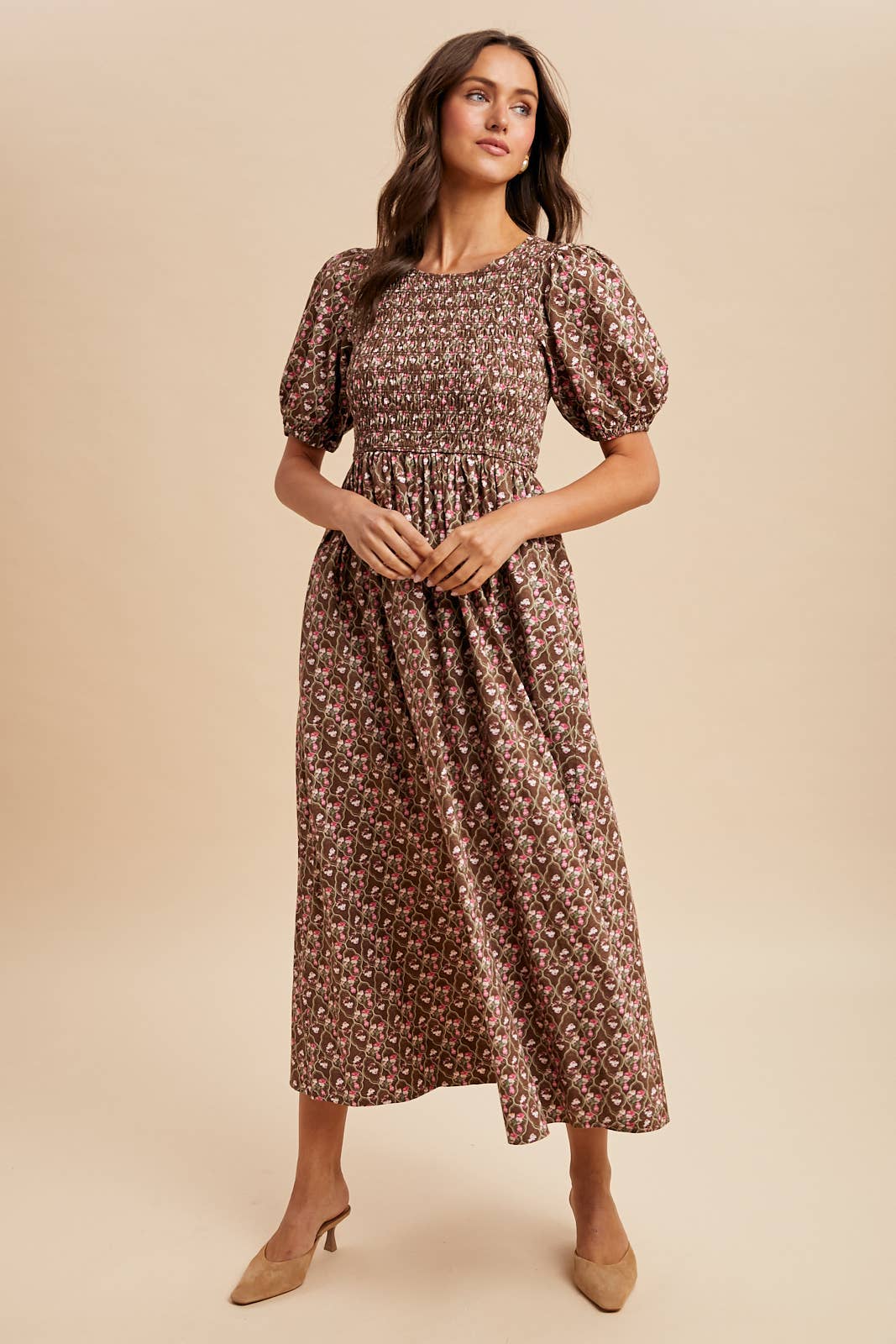 Woman wearing a floral dress against a beige background