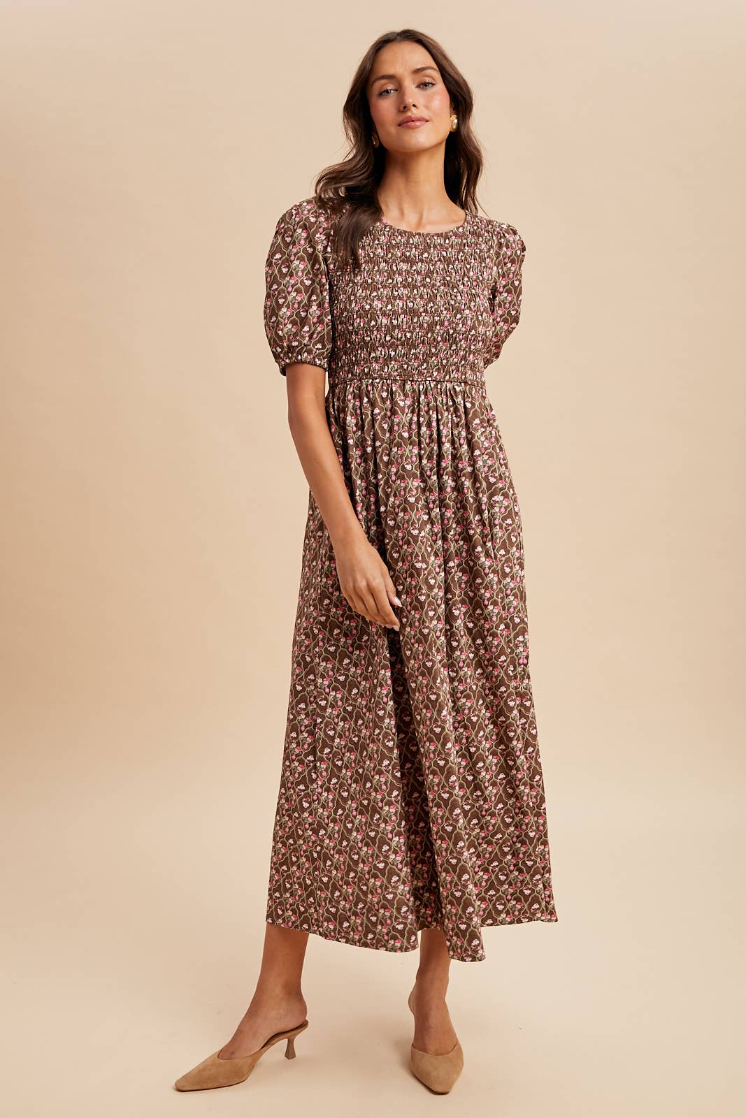 Woman wearing a floral dress against a beige background