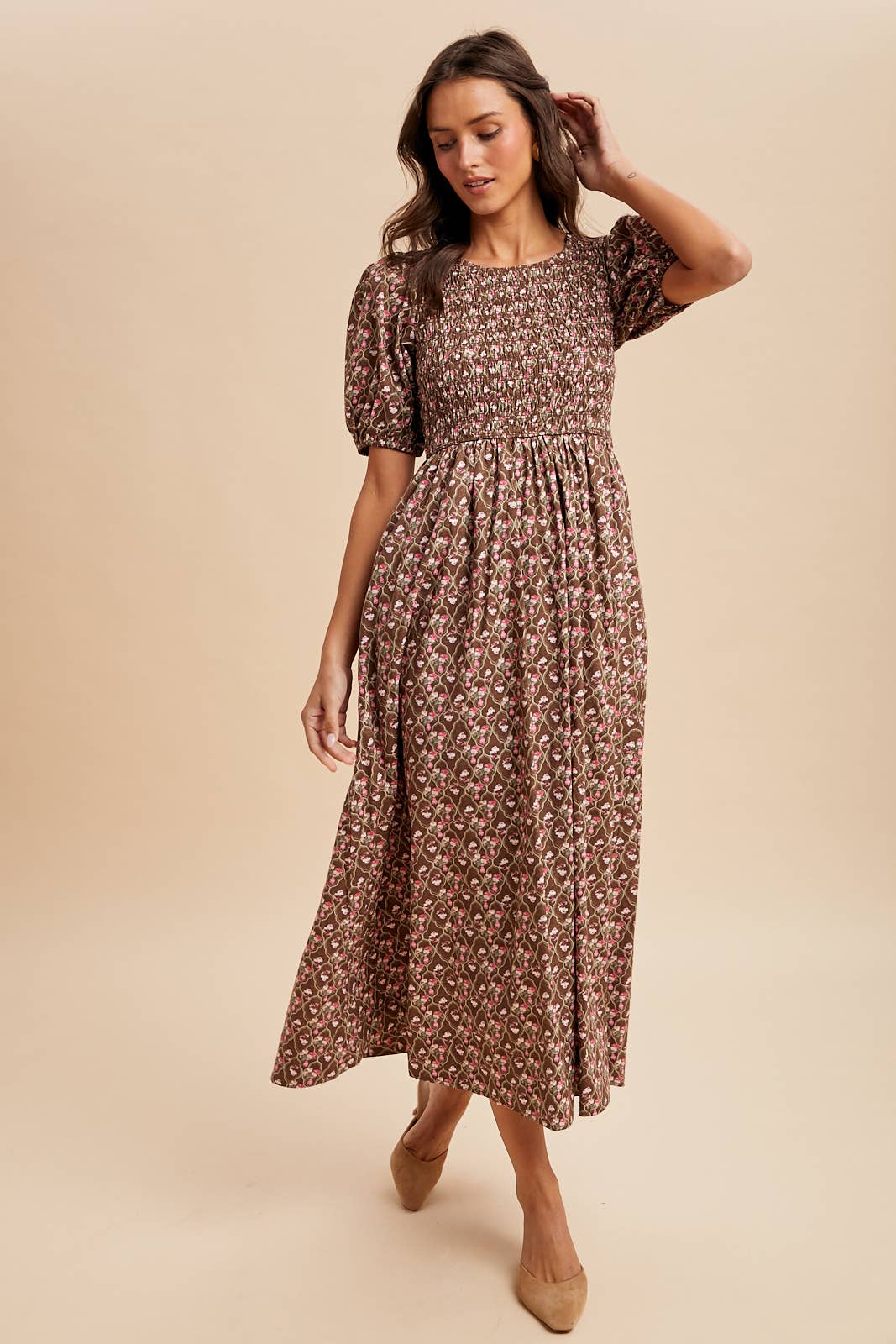Woman wearing a floral dress against a beige background