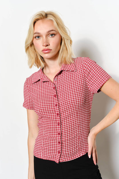Woman wearing a red checkered shirt against a white background