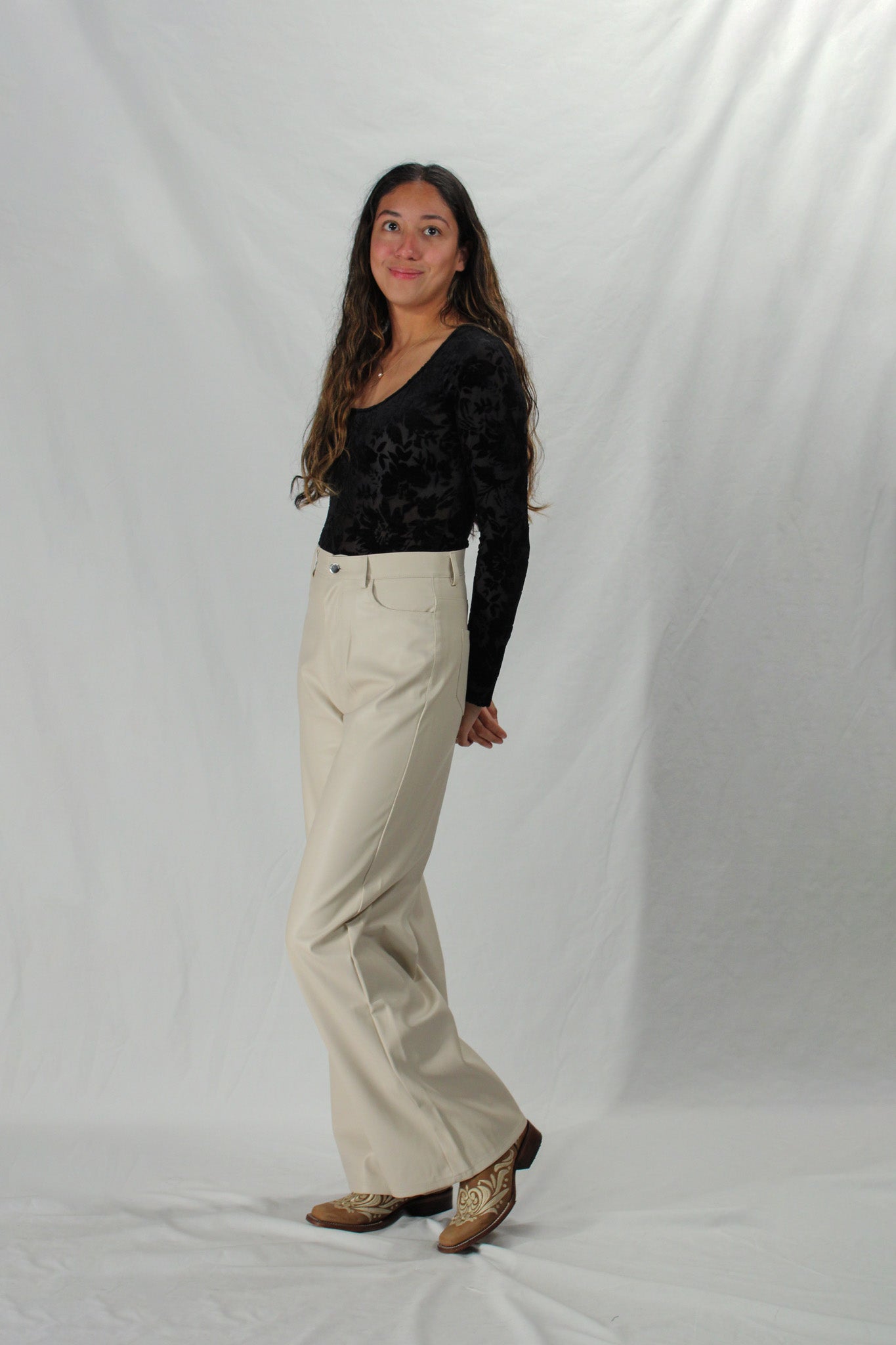 Woman wearing faux leather pants in cream
