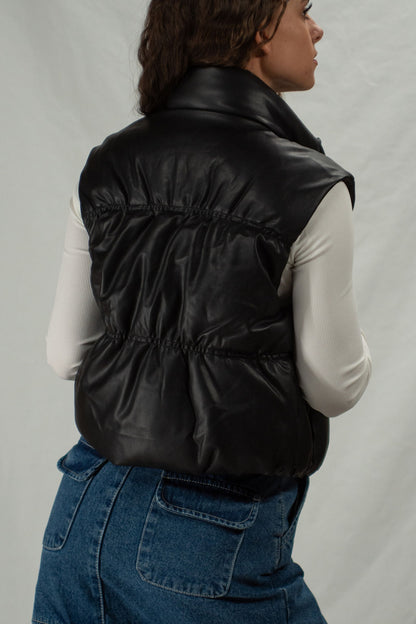 Back of black zip-up vegan leather puffer vest